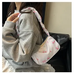 Detail of floral canvas shoulder bag with pink roses and ruffled strap on casual model