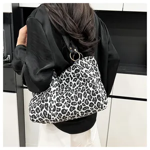 Detail of a zebra print canvas tote bag featuring black shoulder straps and metal rings