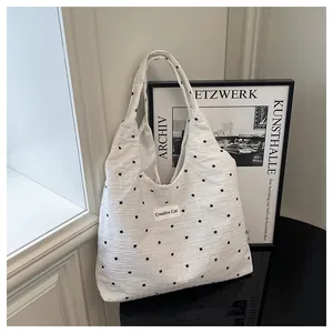Primer plano del bolso tote floral blanco con etiqueta Creative Cat en superficie pulida