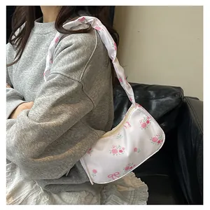 Detailed view of white floral canvas bag with pink roses, bow prints and ruffled shoulder strap