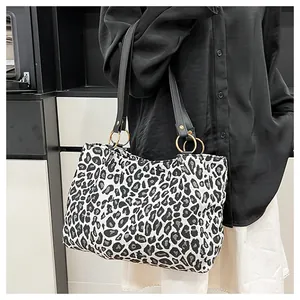 Detail showing the large leopard print tote bag with stylish gold circular metal rings