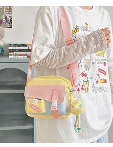 Dettaglio della borsa a tracolla in nylon colorato con ciondolo a luna su modella