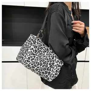 Close-up of zebra pattern tote bag featuring premium gold buckles and black leather straps