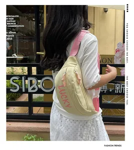 Detail der beige Nylontasche mit rosa LUCKY-Druck und verstellbarem Schultergurt