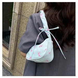 Close-up of light blue floral canvas bag with pink rose patterns and bow details