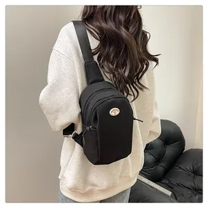 Rear view of model wearing a minimalist black nylon chest bag with adjustable strap