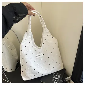 Detalle del bolso tote blanco con motivos florales negros y etiqueta de Creative Cat