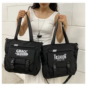 Détail de sacs cabas en nylon noir avec rabat nylon noir avec doubles boucles et imprimé urbain chic