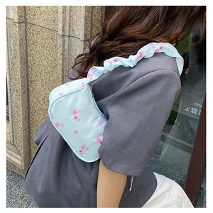 Detail of floral canvas bag featuring pink roses with ruffled shoulder strap detail