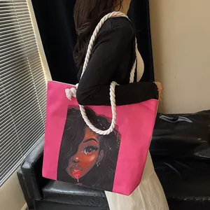 Magenta canvas tote bag with portrait illustration and white rope handles on shoulder