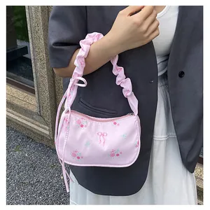 Detail of pink floral satin bag featuring ruffles handle and sweet bow patterns