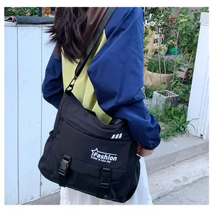 Détail du grand sac messager noir avec bandoulière réglable et fermeture à boucle