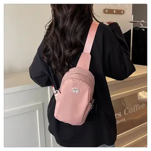 Detailed back view of pink nylon chest bag with adjustable strap worn by a model