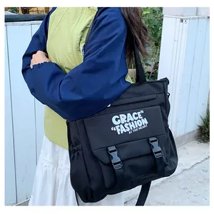 Détail du sac à bandoulière en nylon noir avec fermoirs à boucle et cordons latéraux