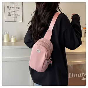 Macro detail of pink waterproof nylon chest bag featuring dual zippers and adjustable strap