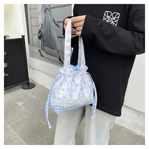 Detail of floral and plaid drawstring bag with lace trim and sweet pastoral design
