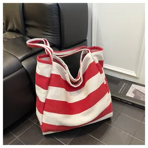 Detail of red and white striped canvas tote bag showing the thick fabric texture and strap