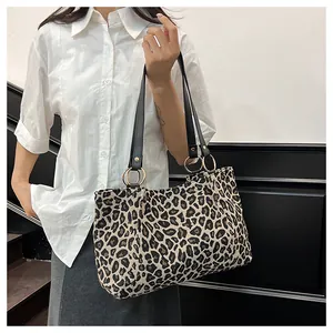 Detail of leopard print tote bag with black straps and golden ring metal hardware