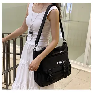 Détail du sac à bandoulière en toile noire avec sangle réglable et imprimé mode