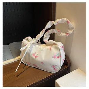 Detailed view of floral canvas bag with pink rose patterns and pleated handle