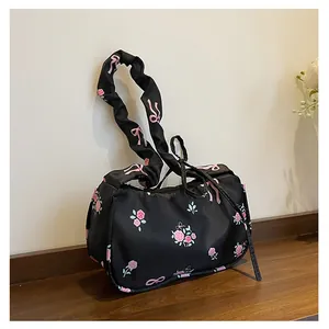 Detail of black floral canvas bag with pink roses, bow prints and ruched strap texture