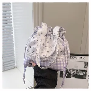 Detailed view of floral and plaid patchwork bag with delicate white lace trim