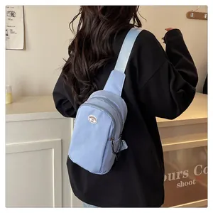 Detailed back view of a light blue nylon chest bag with adjustable shoulder strap