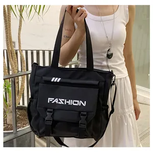 Détail du sac fourre-tout en toile noire avec lettrage fashion et boucles en plastique