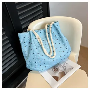 Detailed shot of light blue bubble texture tote bag with black bows and white rope handles