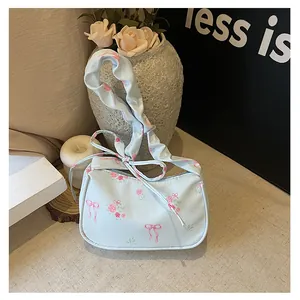 Close-up of floral canvas bag with pink roses, bow pattern and pleated shoulder strap