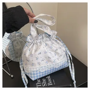Detail view of floral and gingham drawstring bucket bag with delicate lace trim