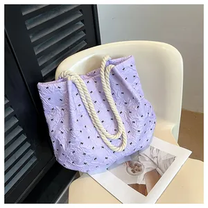 Top view of light purple quilted tote bag with black bows and thick cotton rope handles