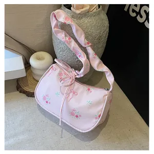 Detail of pink floral canvas shoulder bag with rose patterns and ribbon drawstring