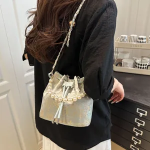 Elegant light blue jacquard bucket bag with pearl handle and golden floral embroidery