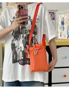 Detail der orangefarbenen Umhängetasche aus Nylon mit Kordelzug und Reißverschluss