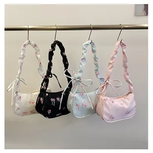 Detail view of floral canvas shoulder bags with drawstring bows in four colors