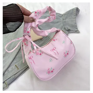 Close-up of pink floral canvas bag with rose patterns and ruffled shoulder strap detail