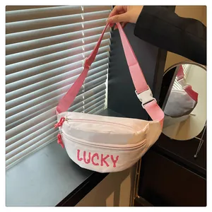 Detail der rosa Umhängetasche mit Lucky-Aufdruck, Doppelreißverschluss und weißer Schnalle
