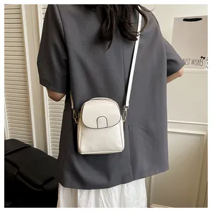 Rear view of a model wearing a chic off-white vertical crossbody bag with double zippers