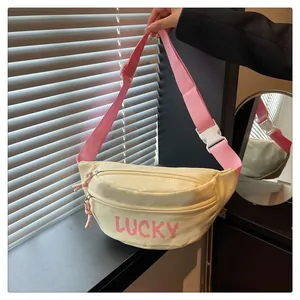 Nahaufnahme der gelben Nylon-Umhängetasche mit Lucky-Aufdruck und rosa Gurt