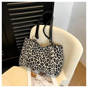Close-up of leopard print canvas tote with black leather handles and metal rings