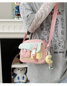 Dettaglio della borsa a tracolla in nylon multicolore con cinturino rosa e ciondolo
