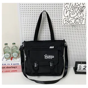 Détail du grand sac cabas noir en toile avec poche à rabat et bandoulière réglable