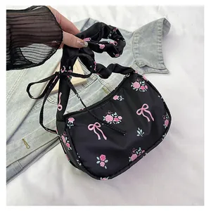 Detailed close-up of a floral nylon bag with pink roses and ruffled handle texture