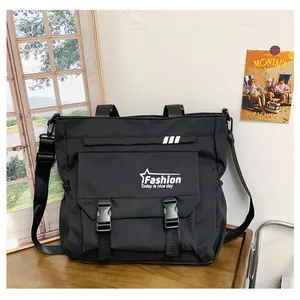 Détail du sac fourre-tout noir avec boucles en plastique et logo blanc imprimé