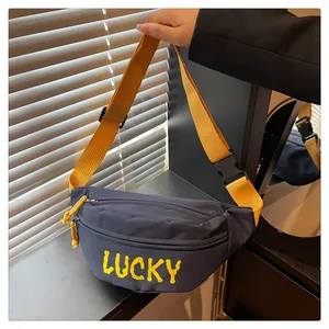 Detail der marineblauen Canvas-Gürteltasche mit gelbem Lucky-Text und Gurtband