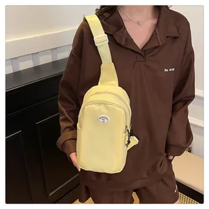 Close-up of cream yellow nylon chest bag featuring adjustable strap and branded patch