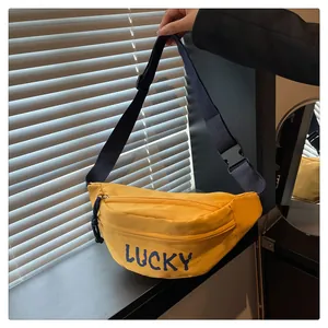 Nahaufnahme der hellgelben Gürteltasche mit blauem LUCKY-Schriftzug und verstellbarem Gurt