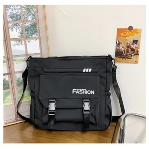 Détail du grand sac bandoulière en nylon noir avec imprimé mode et boucles de fermeture