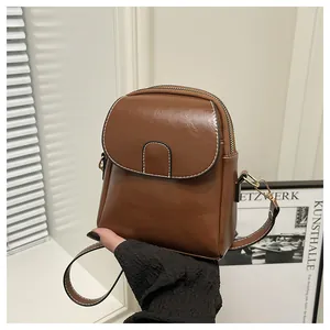 Close-up of a vintage brown crossbody phone bag with a sleek PU leather finish